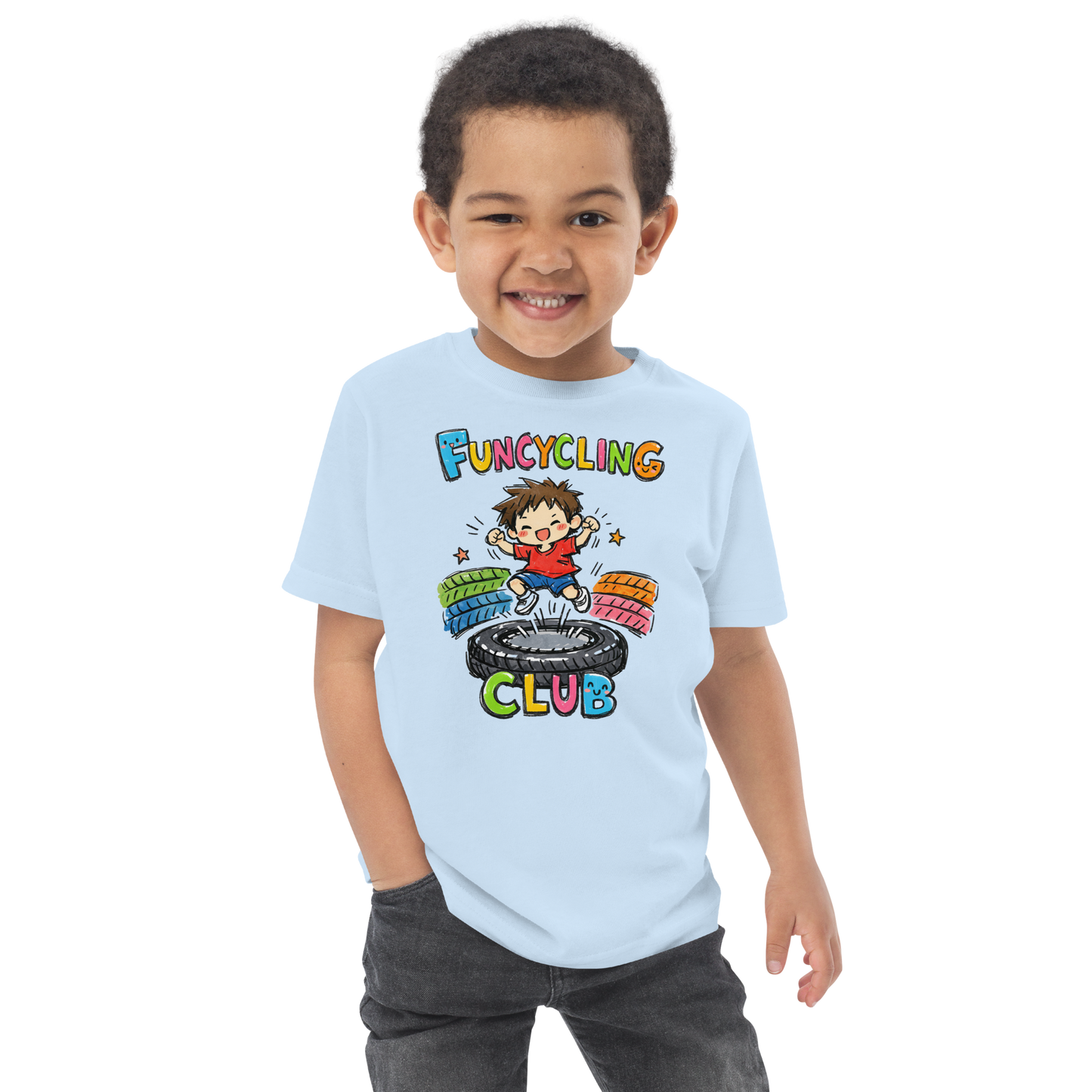 Ein Junge trägt ein hellblaues T-Shirt mit buntem "Funcycling Club" Print und einem Jungen der auf einem Reifen Trampolin springt