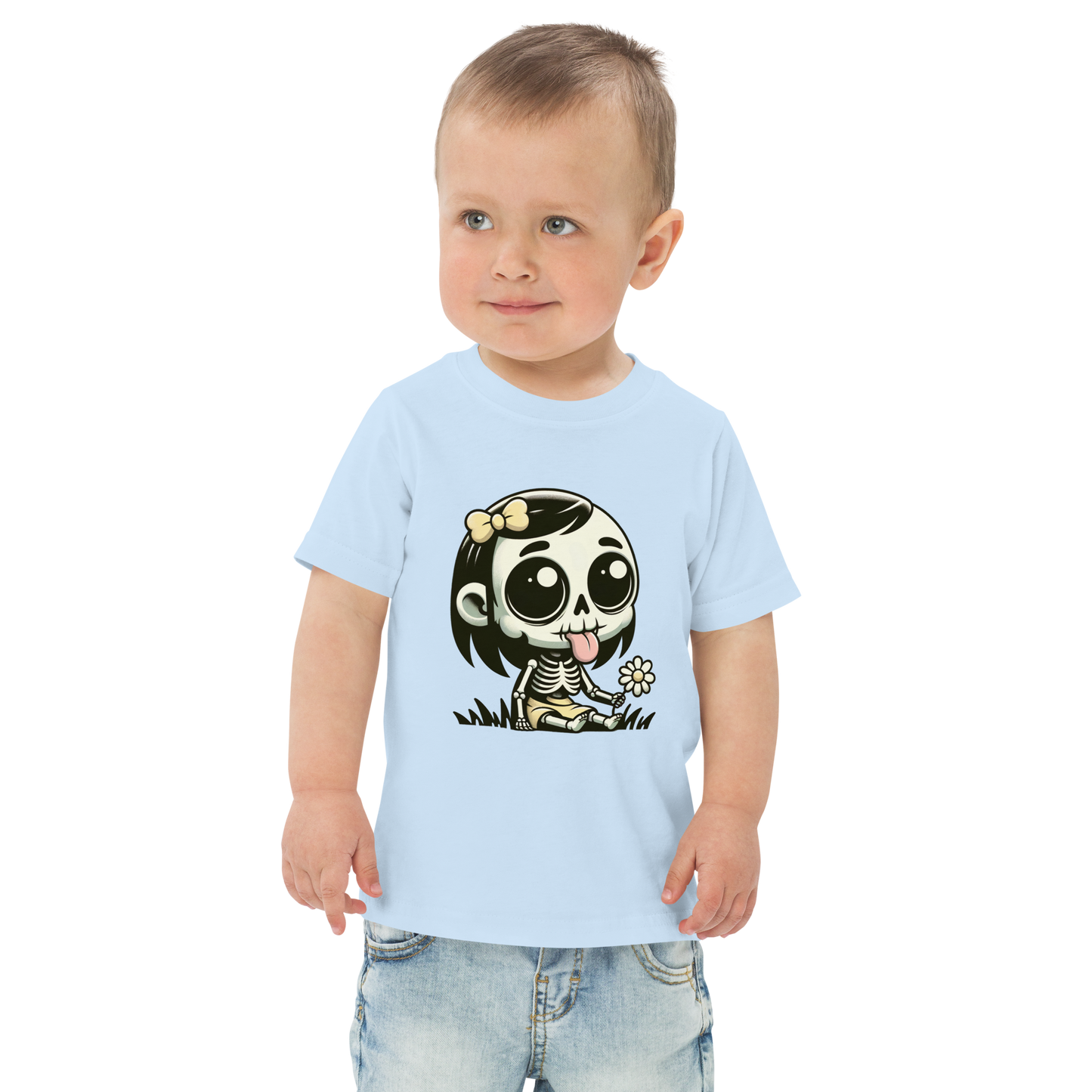 Kleiner Junge trägt hellblaues T-Shirt mit kleinem Skelettmädchen das die Zunge rausstreckt