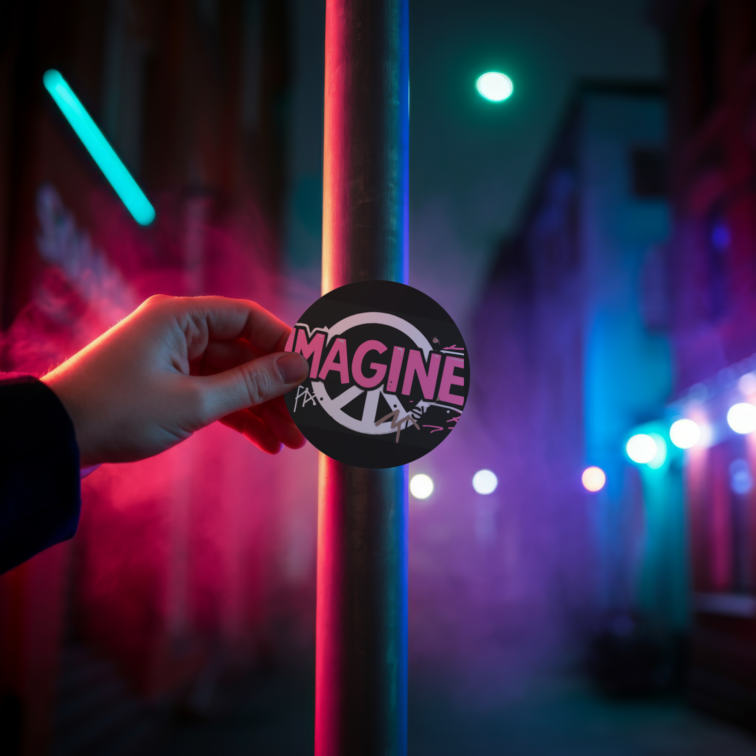 Eine Hand klebt einen Sticker mit Peace Zeichen und dem Wort Imagine an eine Stange