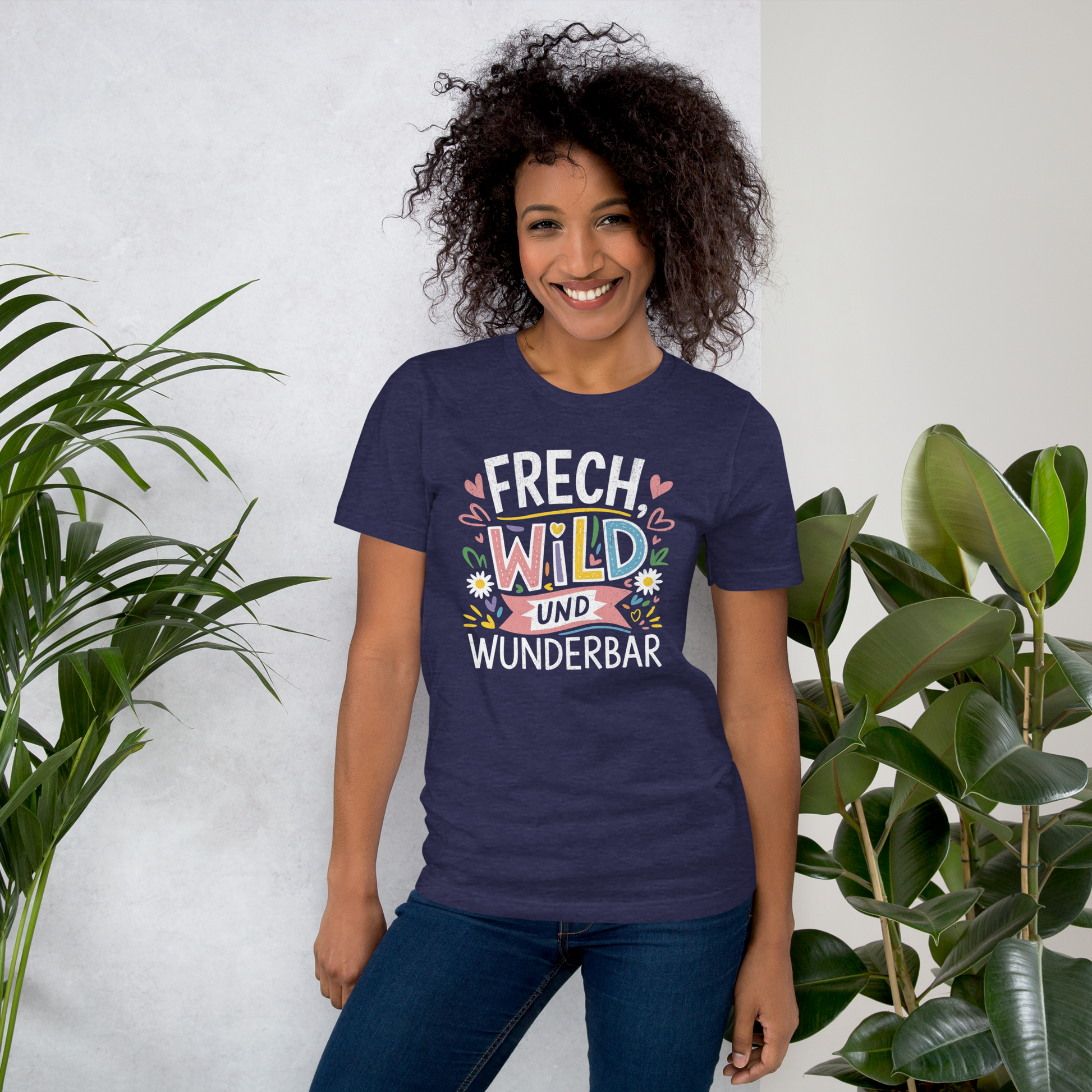 Frau trägt Mitternachts blaues Unisex T-Shirt mit buntem Frech, Wild und Wunderbar Text und Herzen und Blumen