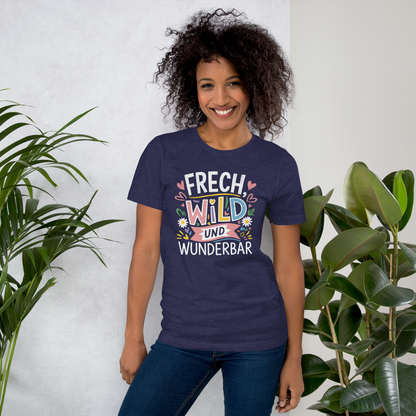 Frau trägt Mitternachts blaues Unisex T-Shirt mit buntem Frech, Wild und Wunderbar Text und Herzen und Blumen
