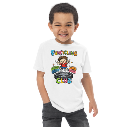 Ein Junge trägt ein weißes T-Shirt mit buntem "Funcycling Club" Print und einem Jungen der auf einem Reifen Trampolin springt