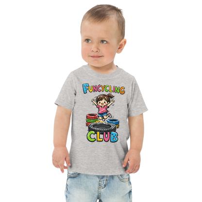 Ein Junge trägt ein graues T-Shirt mit buntem "Funcycling Club" Print und einem Mädchen, das auf einem Reifen Trampolin springt