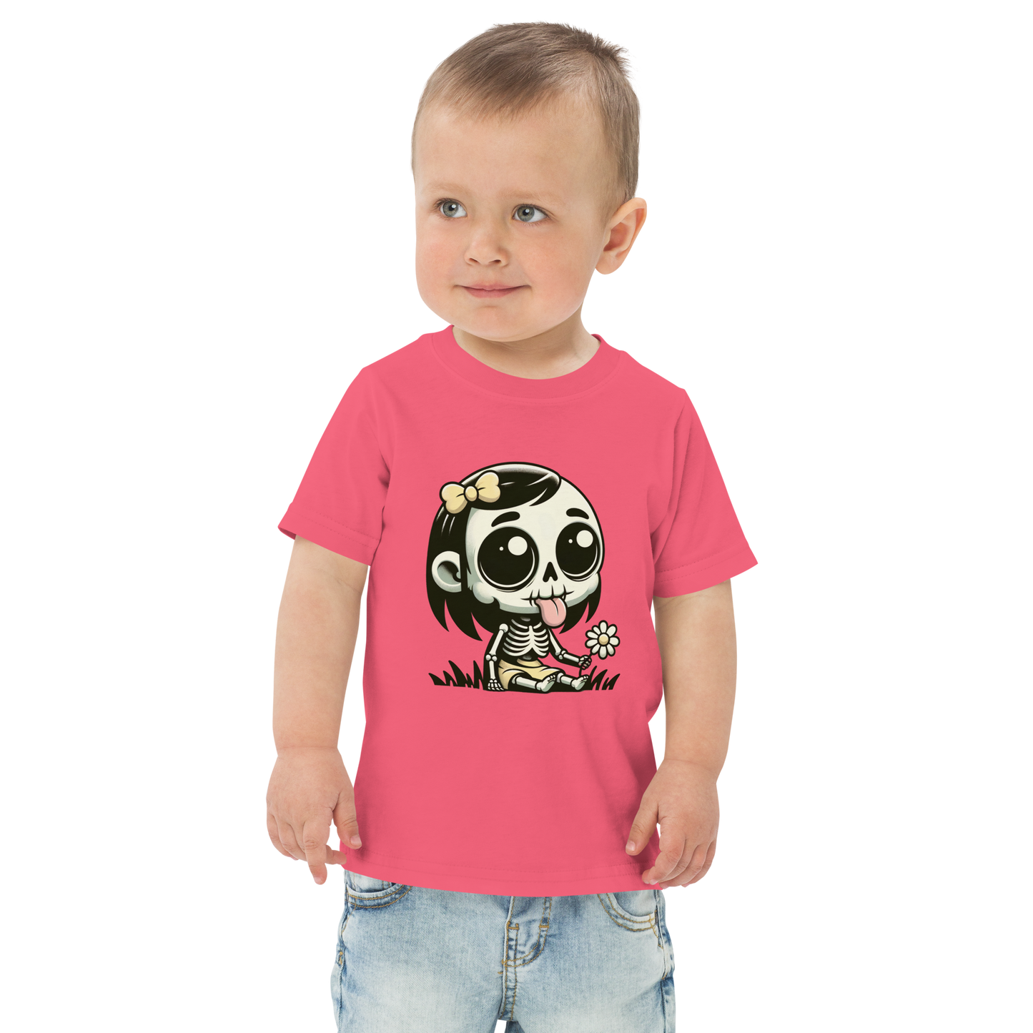 Kleiner Junge trägt pinkes T-Shirt mit kleinem Skelettmädchen das die Zunge rausstreckt