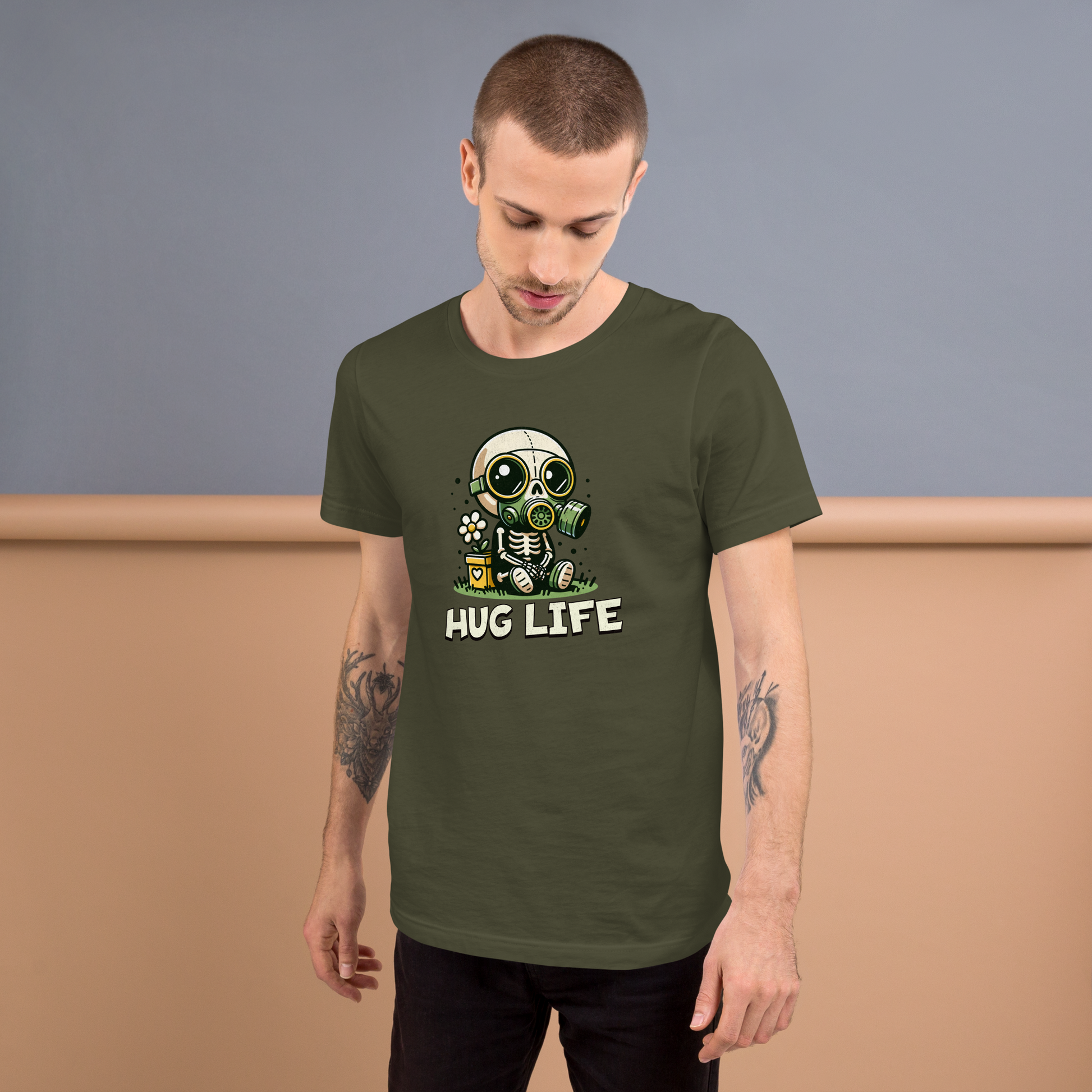 Mann trägt Militärgrünes Unisex T-Shirt mit kleinem Skelettmännchen mit Gasmaske und dem Schriftzug Hug Life