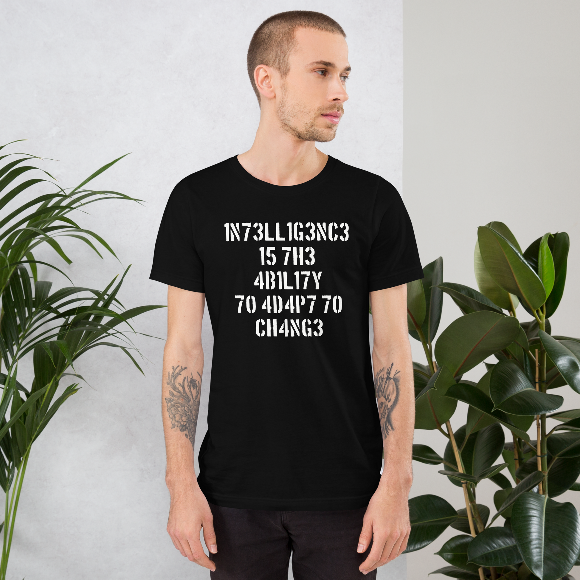 Mann trägt schwarzes Unisex T-Shirt mit Intelligence is the Ability to Change mit Zahlen statt Buchstaben