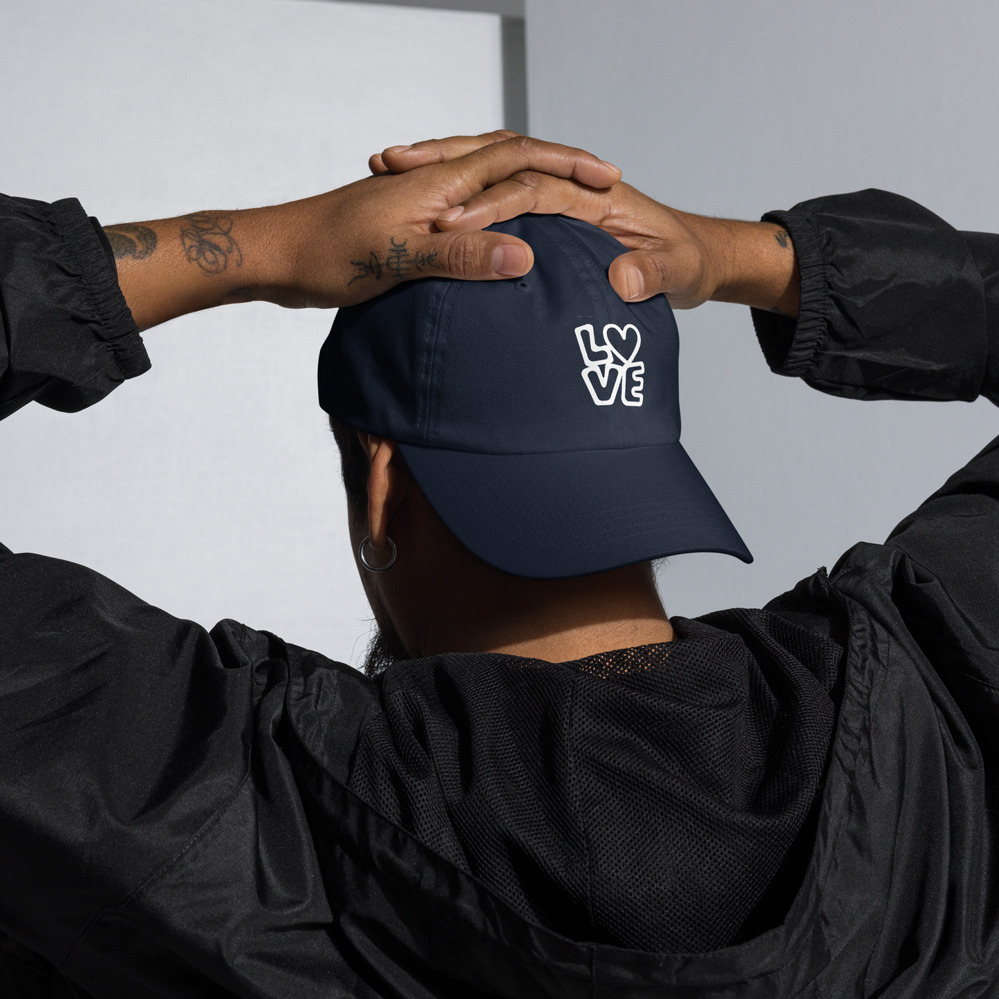 Mann trägt navy Cap mit LOVE Print bei dem das O durch ein Herz ersetzt ist