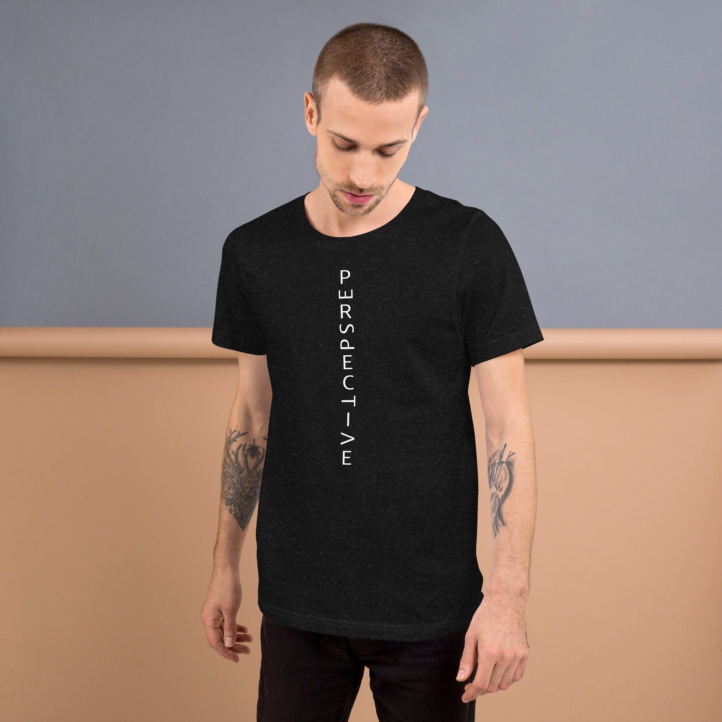 Mann trägt heather schwarzes Unisex T-Shirt mit minimalistischem Perspective Print mit verdrehten Buchstaben