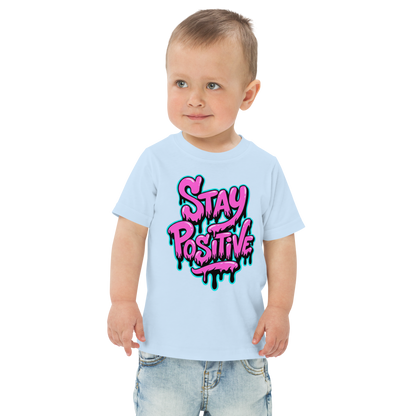 Kind trägt hellblaues Kinder T-Shirt mit pinkem"Stay positive" Graffiti