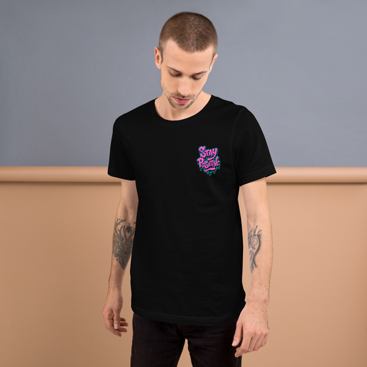 Mann trägt schwarzes Unisex T-Shirt mit Stay Positive Schriftzug in Pink und blauer Outline mit Farbtropfen