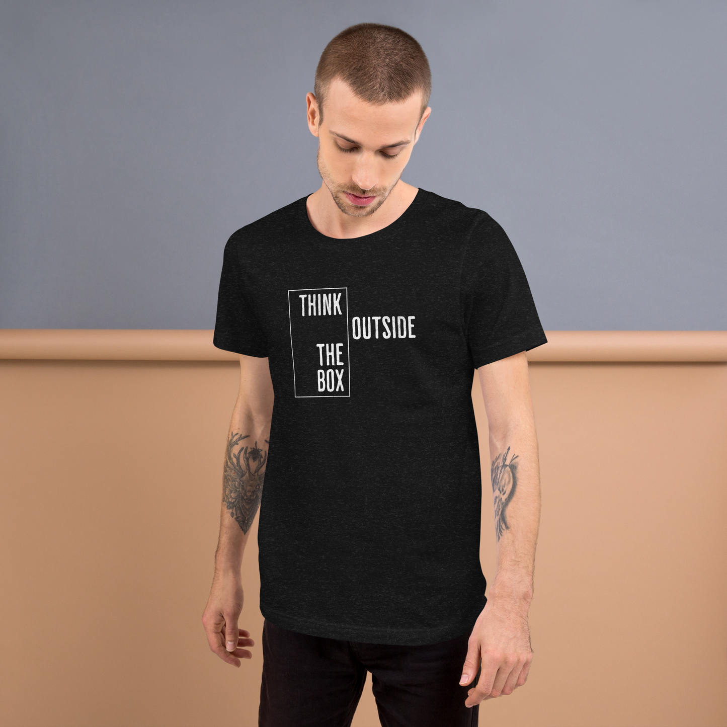 Mann trägt Heather schwarzes Unisex T-Shirt mit Think outside the Box Print